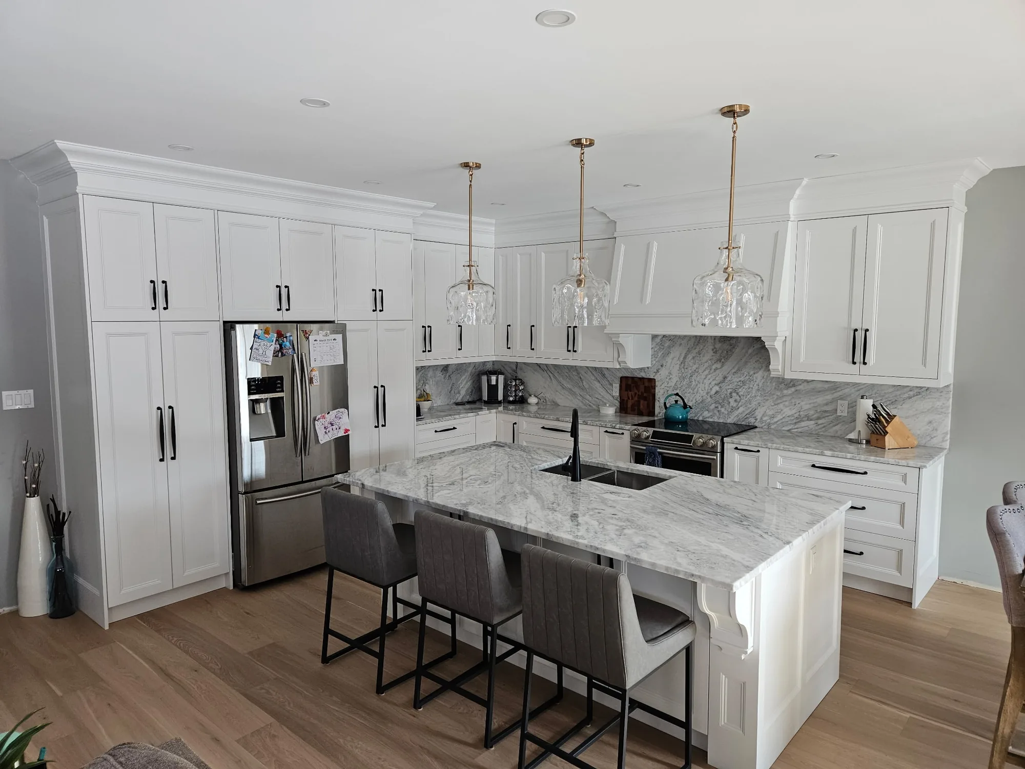 Canadian-Made Custom Cabinetry & Built-In Furniture 2 Canadian-made cabinetry in an Ontario home: floor-to-ceiling white shaker cabinetry, a waterfall-edge island and counter seating.